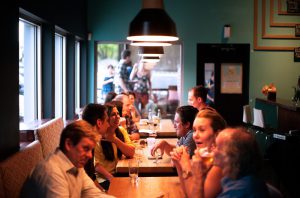 grupos de personas comiendo en un a cafetería